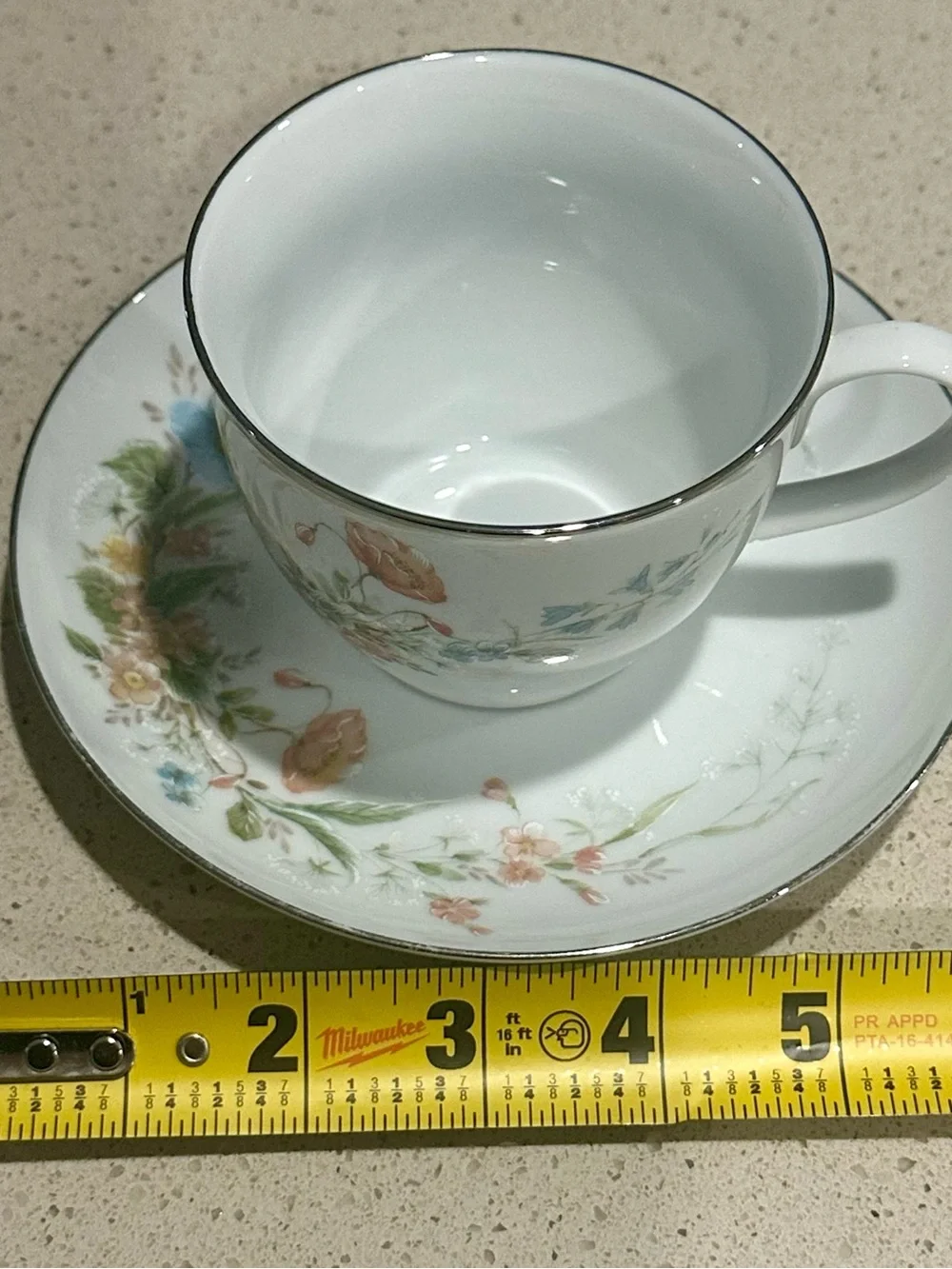 White Porcelain Teacup and Saucer with Pastel Floral Design and Gold Trim